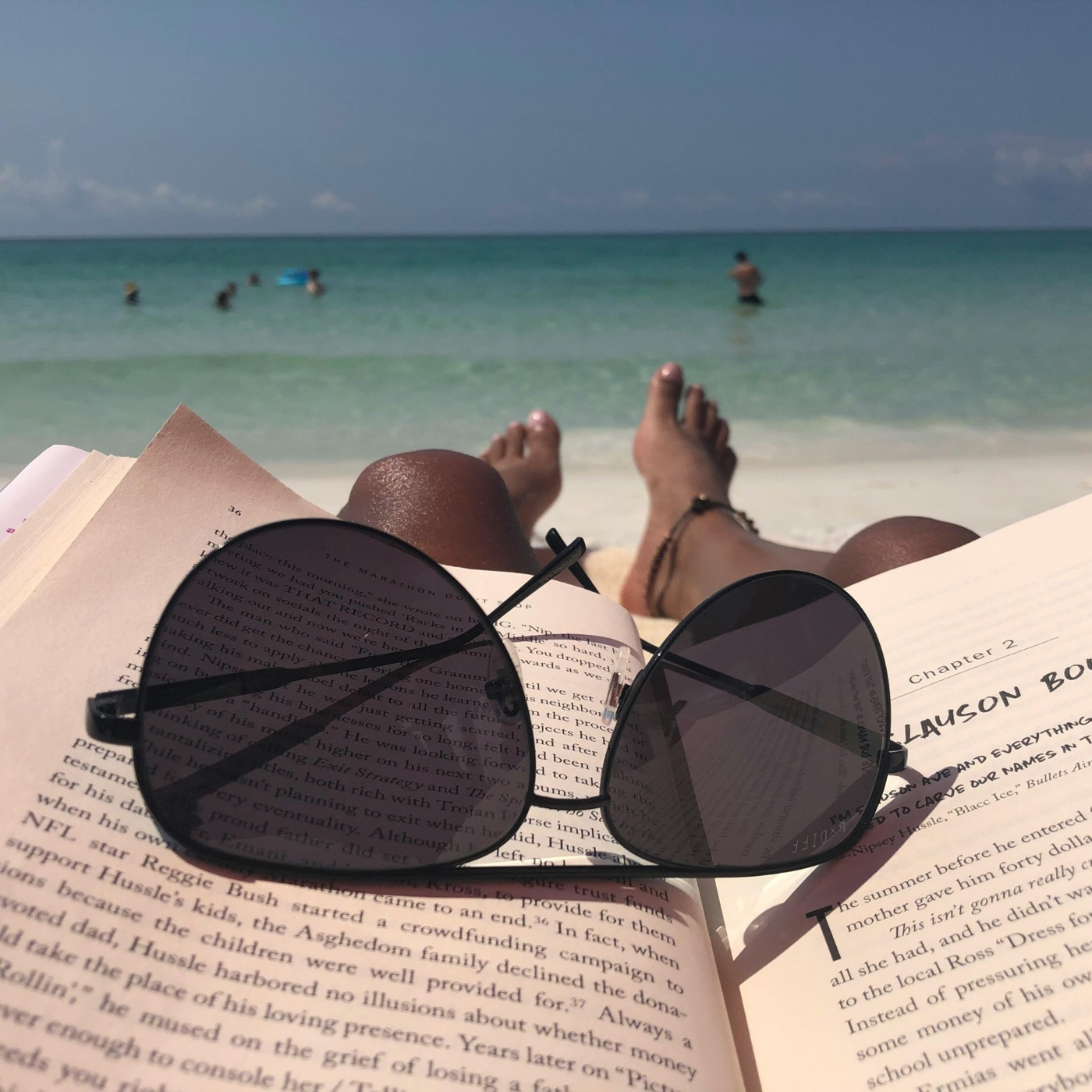 Reading on white sand beside clear turquoise water, minutes from home